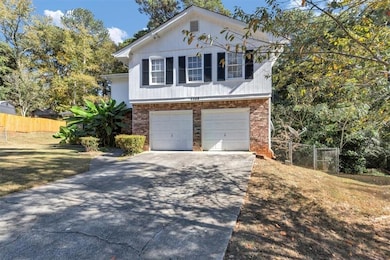 View of front of home with brick siding, driveway, and a garage