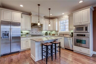 Chef's kitchen with distressed cabinets & island with bar seating.