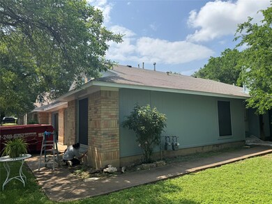 View of property exterior with a yard, brick sidi