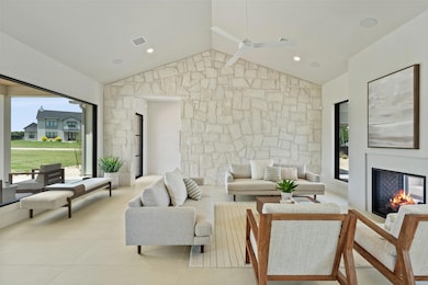 Tiled living room featuring a glass covered firep