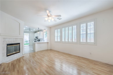 Unfurnished living room featuring ceiling fan, lig
