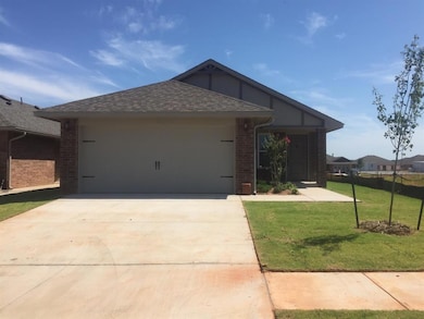 Ranch-style home featuring a garage, brick siding, concrete driveway, a front lawn, and roof with shingles