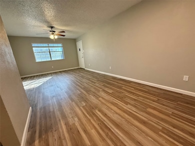 Unfurnished room featuring wood finished floors, a textured ceiling, and ceiling fan