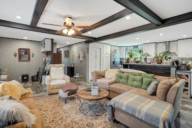 Living room featuring beamed ceiling, beverage cooler, ceiling fan, and recessed lighting