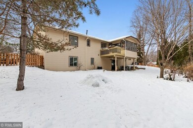 Back of home with huge fenced yard, shows sunroom