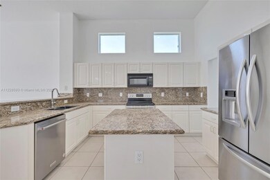 Light and bright island kitchen.  French door refrigerator.  The dishwasher is new.