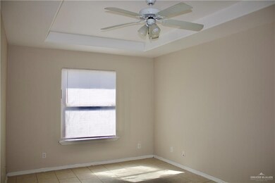 Spare room featuring baseboards, a ceiling fan, and a raised ceiling