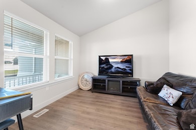 Living room with vaulted ceiling and light wood finished floors