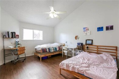 Bedroom with wood finished floors, high vaulted c