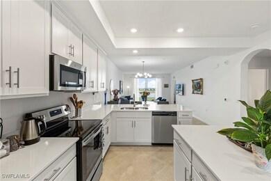 Kitchen with appliances with stainless steel finishes, white cabinetry, hanging light fixtures, a peninsula, and recessed lighting