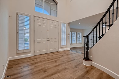 Entryway with baseboards, stairs, wood finished fl