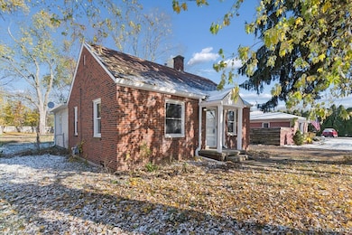View of front of home featuring brick siding and a chimney