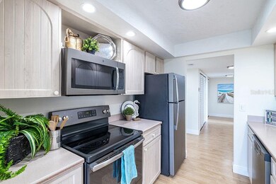 Kitchen has wood cabinets, solid surface counterto