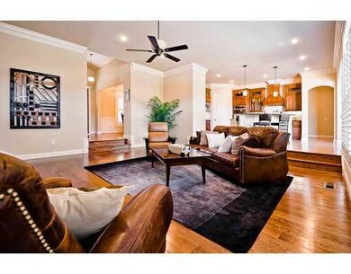 Living Room. Open living features fireplace, sound system, crown molding, wide plank floors.