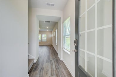 Corridor featuring wood finished floors and basebo