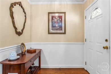 Elegant foyer w/ wainscoting & hard wood flooring.