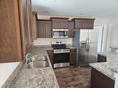 Kitchen featuring dark brown cabinetry, sink, appl