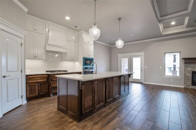 Kitchen featuring premium range hood, dark hardwoo