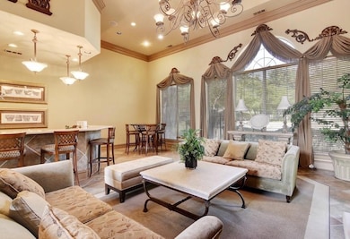 Living room with ornamental molding and a chandel