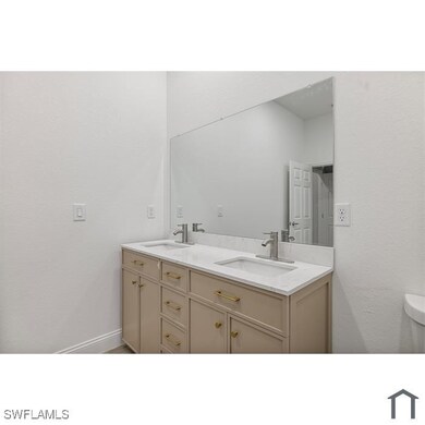Bathroom featuring double vanity, toilet, and a si
