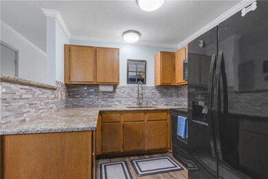 Kitchen featuring black appliances, brown cabinets