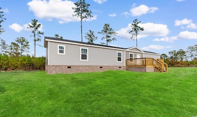 Back of house with crawl space, a yard, a wooden deck, and stairs