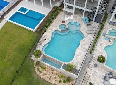 View of swimming pool featuring a pool with connected hot tub and a patio