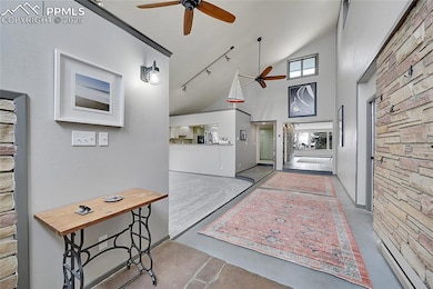 Foyer featuring ceiling fan, high vaulted ceiling,