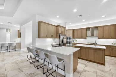 Kitchen with a kitchen bar, a peninsula, recessed lighting, and brown cabinetry