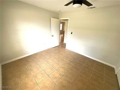 Tiled empty room with baseboards and a ceiling fan