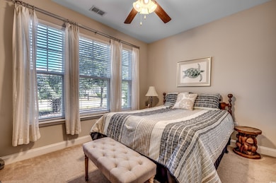 Carpeted bedroom featuring ceiling fan and multipl