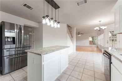 Kitchen with a chandelier, stainless steel fridge