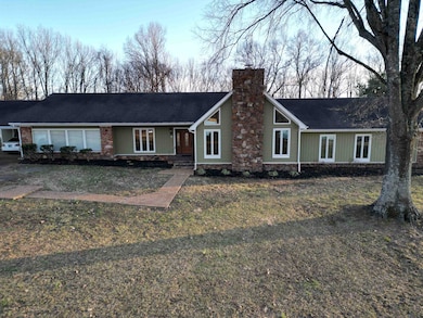 View of front of home with a chimney and roof with