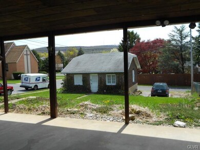 From rear porch looking over yard to garage & publ