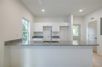 Kitchen with white cabinetry, kitchen peninsula, s