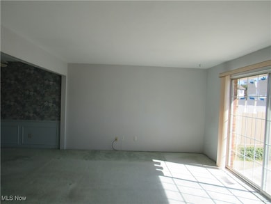 Carpeted spare room with a wainscoted wall and wallpapered walls