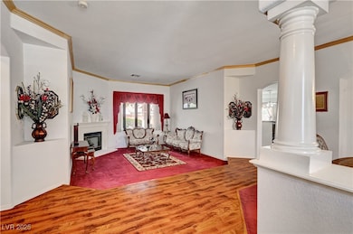 Living area featuring ornate columns, wood finishe