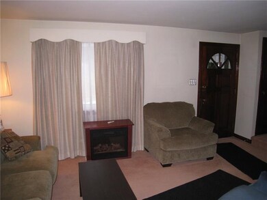 The living room has wall to wall carpet, there are