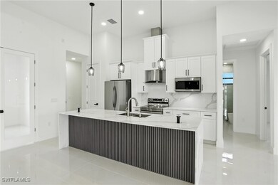 Kitchen with stainless steel appliances, white cab