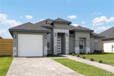Prairie-style house featuring a shingled roof, an attached garage, stucco siding, a front lawn, and decorative driveway