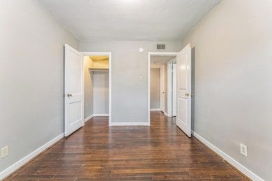 Unfurnished bedroom with wood finished floors, ba