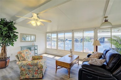 Living area with healthy amount of natural light, wood finished floors, and ceiling fan