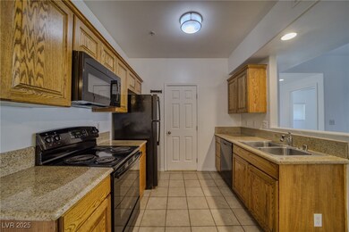 Kitchen featuring black appliances, light tile patterned floors, brown cabinets, recessed lighting, and light stone countertops