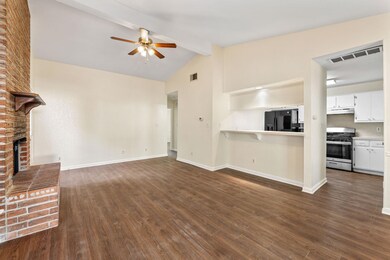 Unfurnished living room with beam ceiling, dark wood finished floors, a fireplace, ceiling fan, and high vaulted ceiling