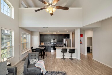 Living room with a towering ceiling, ceiling fan, and light wood-type flooring