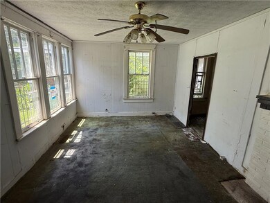 Spare room featuring a textured ceiling, a ceiling fan, and wood walls