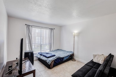 Bedroom featuring light tile patterned floors, bas