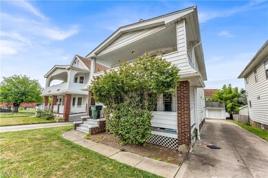 View of front facade featuring a garage, covered porch, an outdoor structure, and a front yard