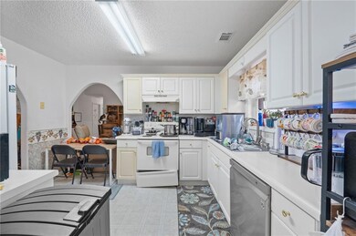 Kitchen featuring white cabinetry, dishwasher, sin