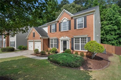 Colonial-style house with brick siding, driveway, and an attached garage